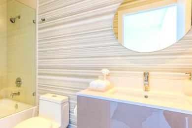 Foto de cuarto de baño moderno con combinación de ducha y bañera, paredes beige y lavabo integrado