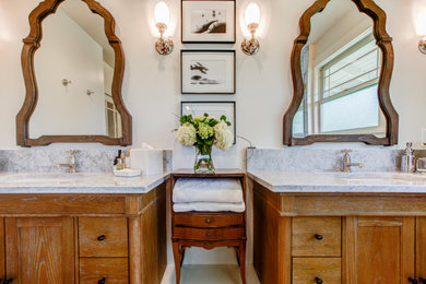 Example of a large classic master double-sink bathroom design in Denver with beaded inset cabinets, light wood cabinets, marble countertops, a hinged shower door and a built-in vanity