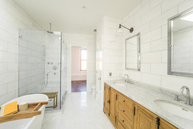 Inspiration for a timeless white tile corner shower remodel in New York with medium tone wood cabinets and an undermount sink