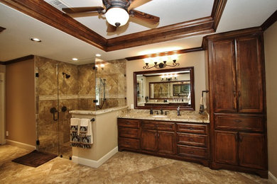 Example of a large classic master beige tile and porcelain tile porcelain tile double shower design in Houston with an undermount sink, recessed-panel cabinets, dark wood cabinets, granite countertops, a two-piece toilet and beige walls