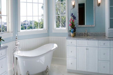 Diseño de cuarto de baño principal clásico de tamaño medio con armarios estilo shaker, puertas de armario blancas, bañera con patas, paredes azules, suelo de baldosas de cerámica, lavabo bajoencimera, encimera de granito y suelo blanco