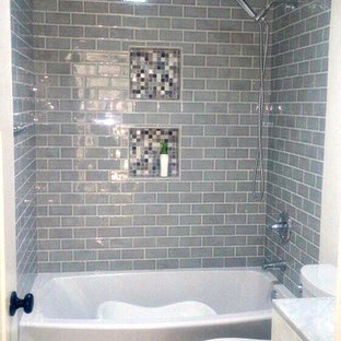 Exempel på ett mellanstort klassiskt en-suite badrum, med luckor med upphöjd panel, skåp i mörkt trä, en jacuzzi, en dusch i en alkov, en toalettstol med separat cisternkåpa, grå kakel, kakelplattor, grå väggar, kalkstensgolv, ett undermonterad handfat, marmorbänkskiva, grått golv och med dusch som är öppen