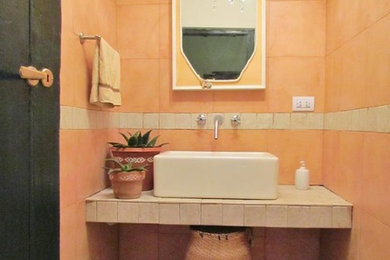 Foto de cuarto de baño ecléctico con baldosas y/o azulejos naranja y lavabo de seno grande