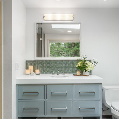 Inspiration for a transitional master porcelain tile bathroom remodel in Seattle with flat-panel cabinets, a one-piece toilet, white walls, an undermount sink, quartz countertops and blue cabinets