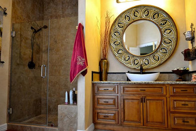 Example of a mid-sized classic master corner shower design in Austin with a vessel sink, raised-panel cabinets, medium tone wood cabinets, granite countertops and beige walls
