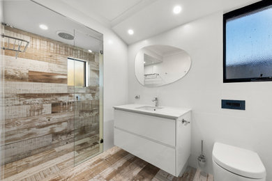 Design ideas for a medium sized coastal shower room bathroom in Perth with flat-panel cabinets, white cabinets, an alcove shower, a one-piece toilet, white tiles, ceramic tiles, white walls, porcelain flooring, a submerged sink, brown floors, an open shower and white worktops.