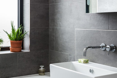 ロンドンにある中くらいなコンテンポラリースタイルのおしゃれな浴室 (ドロップイン型浴槽、壁付け型シンク、洗面台1つ) の写真
