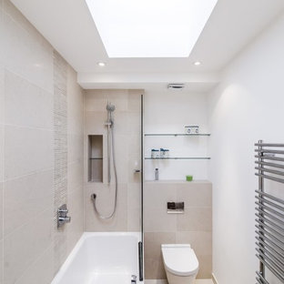 Immagine di una stanza da bagno padronale contemporanea di medie dimensioni con vasca/doccia, WC sospeso, piastrelle beige, piastrelle in gres porcellanato, pareti bianche, pavimento in gres porcellanato e vasca ad alcova