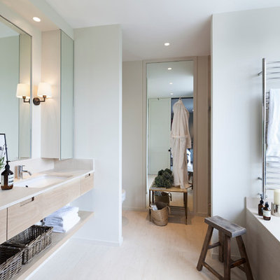 Inspiration for a scandinavian master light wood floor bathroom remodel in London with an undermount sink, light wood cabinets, an undermount tub, flat-panel cabinets and white walls