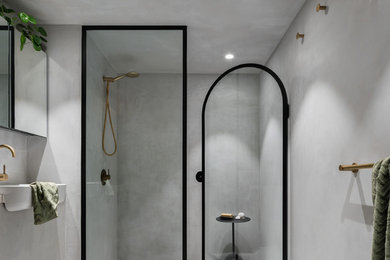 Exempel på ett litet modernt grå grått en-suite badrum, med släta luckor, grå skåp, en dusch i en alkov, grå kakel, grå väggar, betonggolv, bänkskiva i betong, grått golv och dusch med gångjärnsdörr