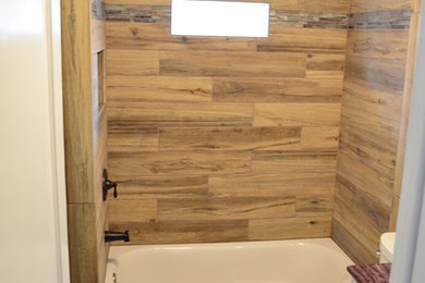 Photo of a medium sized rural family bathroom in Philadelphia with recessed-panel cabinets, white cabinets, an alcove bath, a two-piece toilet, brown tiles, porcelain tiles, green walls, vinyl flooring, a submerged sink and marble worktops.