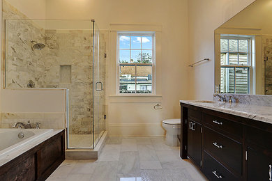 Cette image montre une salle de bain craftsman en bois foncé avec un placard en trompe-l'oeil, un plan de toilette en marbre et un sol en marbre.
