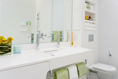 Inspiration for a contemporary bathroom remodel in New York with solid surface countertops and a wall-mount toilet