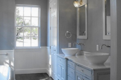 Bathroom - large traditional master dark wood floor bathroom idea in Oklahoma City with a vessel sink, raised-panel cabinets, blue cabinets, marble countertops, a two-piece toilet and blue walls