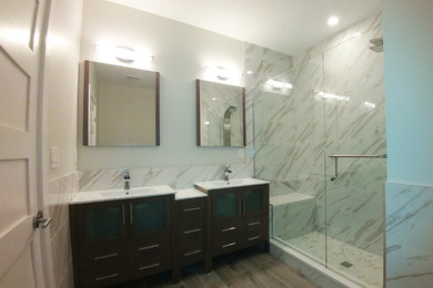Inspiration for a medium sized contemporary shower room bathroom in Philadelphia with flat-panel cabinets, black cabinets, an alcove shower, marble tiles, white walls, porcelain flooring, an integrated sink, quartz worktops, beige floors and a hinged door.