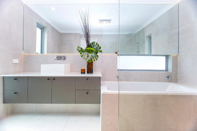 Imagen de cuarto de baño principal contemporáneo de tamaño medio con armarios tipo mueble, puertas de armario verdes, bañera encastrada, ducha abierta, baldosas y/o azulejos grises, lavabo sobreencimera, encimera de cuarzo compacto y ducha abierta
