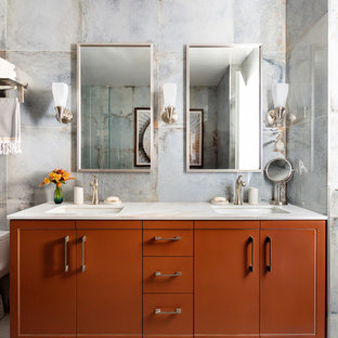 Photo of a mid-sized transitional master bathroom in New York with a bidet, blue tile, porcelain tile, blue walls, marble floors, marble benchtops, white floor, white benchtops, flat-panel cabinets, orange cabinets and an undermount sink.