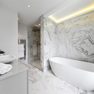 Design ideas for a medium sized modern bathroom in Surrey with flat-panel cabinets, a freestanding bath, a corner shower, marble tiles, grey walls, marble flooring, a vessel sink, white floors, a hinged door and grey worktops.