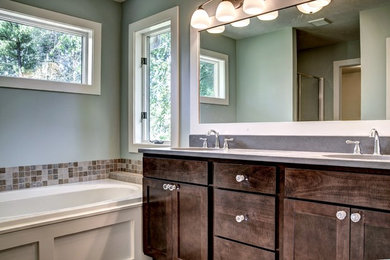Example of a large classic master beige tile and ceramic tile bathroom design in Grand Rapids with an undermount sink, recessed-panel cabinets, dark wood cabinets, granite countertops and green walls