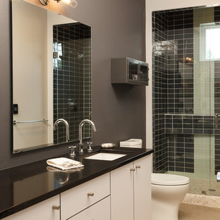 Esempio di una stanza da bagno industriale con lavabo sottopiano, piastrelle nere, piastrelle di vetro, pareti grigie e pavimento in cemento
