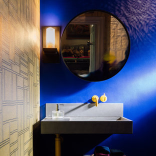 Photo of an eclectic bathroom in London with a wall-mount toilet, blue walls, a wall-mount sink, a single vanity and wallpaper.