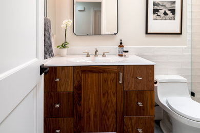Bathroom - small transitional 3/4 white tile and porcelain tile porcelain tile, gray floor, single-sink and wainscoting bathroom idea in San Francisco with flat-panel cabinets, dark wood cabinets, white walls, an integrated sink, solid surface countertops, white countertops and a freestanding vanity