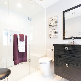 Esempio di una stanza da bagno padronale contemporanea di medie dimensioni con ante lisce, ante nere, doccia a filo pavimento, WC monopezzo, piastrelle bianche, piastrelle di vetro, pareti bianche, pavimento in marmo, lavabo sottopiano e top in granito