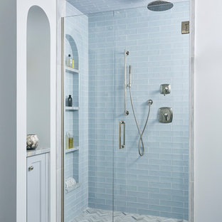Example of a transitional 3/4 blue tile gray floor alcove shower design in Minneapolis with blue cabinets and a hinged shower door
