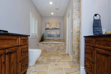 Bathroom - large traditional master brown tile and stone tile travertine floor and brown floor bathroom idea in Other with raised-panel cabinets, dark wood cabinets, gray walls and granite countertops