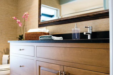Imagen de cuarto de baño actual con armarios con paneles empotrados, puertas de armario de madera clara, sanitario de una pieza y paredes beige