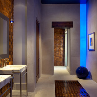 Immagine di una stanza da bagno design con lavabo a consolle e piastrelle effetto legno