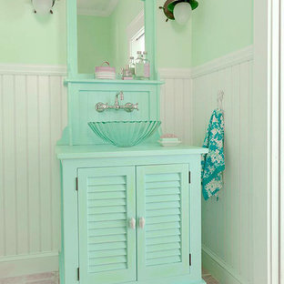 Foto di una stanza da bagno tropicale con consolle stile comò, ante con finitura invecchiata, top in legno e piastrelle beige