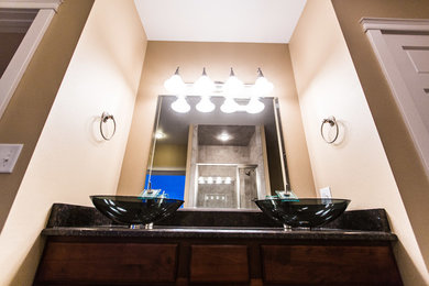 Elegant master bathroom photo in Other with flat-panel cabinets, distressed cabinets, a vessel sink and granite countertops