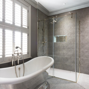Traditional ensuite bathroom in Kent with a freestanding bath, a built-in shower, grey tiles, grey walls, grey floors and a sliding door.
