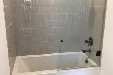 Foto di una stanza da bagno con doccia chic con vasca ad alcova, vasca/doccia, piastrelle grigie, piastrelle in ceramica e doccia aperta