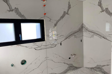 Modelo de cuarto de baño principal moderno con armarios con paneles lisos y encimera de acrílico