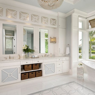 Immagine di una stanza da bagno padronale tropicale con ante con riquadro incassato, ante bianche, vasca freestanding, lavabo sottopiano, pavimento multicolore e top bianco