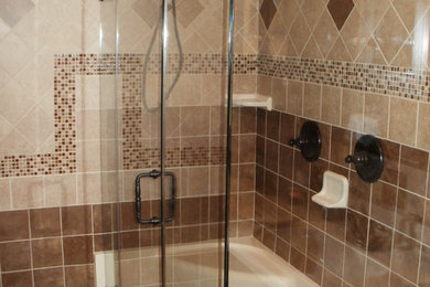 Example of a mid-sized classic master brown tile and ceramic tile ceramic tile corner shower design in New York with recessed-panel cabinets, dark wood cabinets, beige walls, an integrated sink and laminate countertops