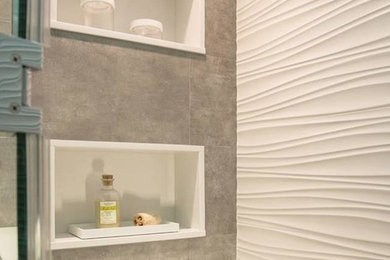 ニューヨークにある中くらいなコンテンポラリースタイルのおしゃれなバスルーム (浴槽なし) (アルコーブ型シャワー、グレーの壁、人工大理石カウンター、開き戸のシャワー) の写真