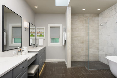 This is an example of a large traditional ensuite bathroom in Portland with raised-panel cabinets, grey cabinets, a freestanding bath, a built-in shower, a two-piece toilet, grey tiles, porcelain tiles, grey walls, porcelain flooring, a submerged sink and engineered stone worktops.