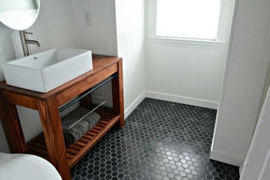 Modelo de cuarto de baño clásico de tamaño medio con paredes grises, suelo de baldosas de cerámica, aseo y ducha, lavabo sobreencimera, encimera de madera, suelo negro y encimeras marrones