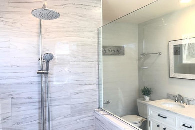 Large transitional master gray tile and stone tile single-sink wet room photo in Boston with shaker cabinets, white cabinets, a freestanding vanity, marble countertops, gray countertops, a two-piece toilet, white walls, an undermount sink and a hinged shower door