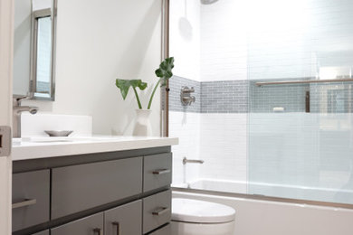 Inspiration for a mid-sized contemporary white tile and subway tile wood-look tile floor, beige floor and single-sink bathroom remodel in San Francisco with flat-panel cabinets, gray cabinets, a one-piece toilet, white walls, an undermount sink, quartz countertops, white countertops, a niche and a built-in vanity