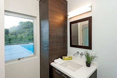 Ispirazione per una piccola stanza da bagno con doccia minimal con lavabo sottopiano, ante lisce, ante in legno bruno e pareti bianche