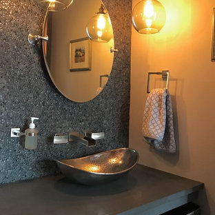 This is an example of a small eclectic 3/4 bathroom in Seattle with black tile, pebble tile, grey walls, cork floors, a vessel sink, solid surface benchtops and brown floor.