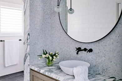 Design ideas for a large contemporary bathroom in Sydney with medium wood cabinets, grey tiles, marble tiles, grey walls, ceramic flooring, a vessel sink, marble worktops and black floors.