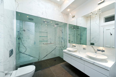 На фото: большая серо-белая ванная комната в современном стиле с настольной раковиной, душем в нише, мраморной столешницей и душем с распашными дверями с