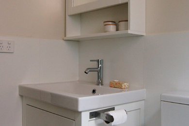 Traditional bathroom in Melbourne with white cabinets and white tiles.