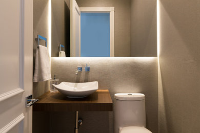 Bild på ett litet funkis badrum med dusch, med beige väggar, träbänkskiva och en toalettstol med hel cisternkåpa