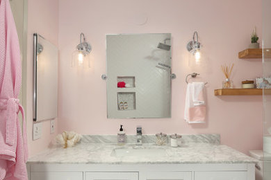 На фото: ванная комната среднего размера в стиле неоклассика (современная классика) с фасадами в стиле шейкер, белыми фасадами, ванной в нише, душем над ванной, унитазом-моноблоком, белой плиткой, розовыми стенами, душевой кабиной, врезной раковиной, серым полом, открытым душем, разноцветной столешницей, керамогранитной плиткой, мраморным полом и мраморной столешницей